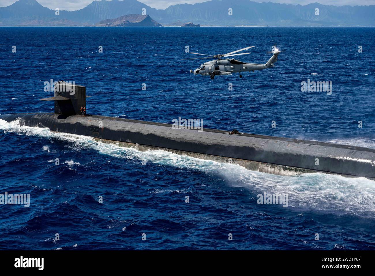 Ein MH-60R Sea Hawk liefert eine Nutzlast zum U-Boot mit ballistischer Rakete USS Henry M. Jackson. Stockfoto