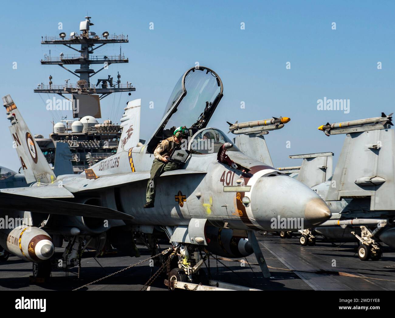 Die Marines untersuchen eine F/A-18C Hornet auf dem Flugdeck des Flugzeugträgers USS Nimitz. Stockfoto