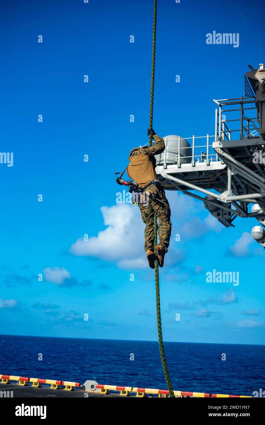 Ein U.S. Marine schnappt sich von einem MV-22 Osprey an Bord der USS Makin Island. Stockfoto