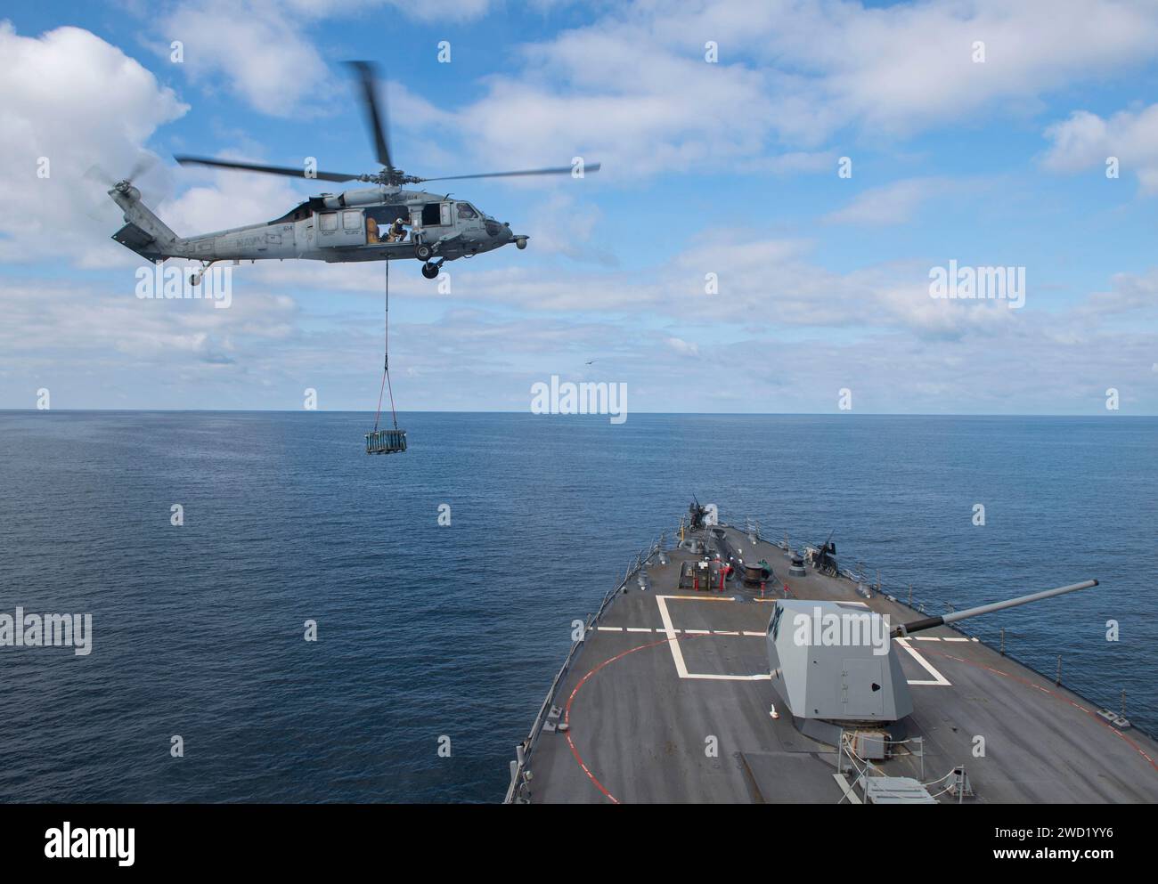 Ein MH-60S Sea Hawk Helikopter wird in Position gebracht, um Frachtpaletten auf dem Bug der USS Sterett abzuwerfen. Stockfoto