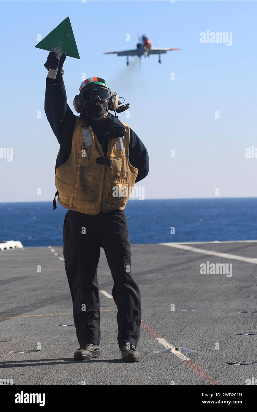 Boatswain's Mate signalisiert einen T-45 Goshawk auf dem Flugdeck der USS Gerald R. Ford. Stockfoto