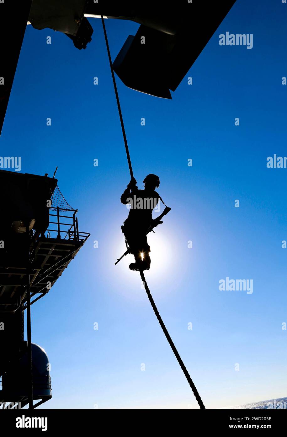 Ein U.S. Marine steigt während eines Schnellseiltrainings an Bord der USS Iwo Jima von einem MV-22B Osprey ab. Stockfoto