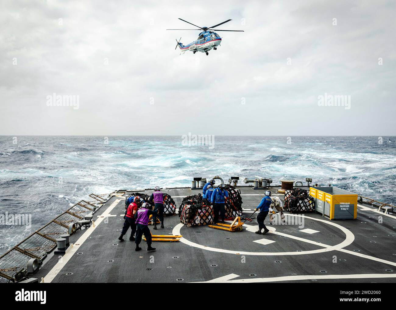 Seeleute transportieren Paletten mit Fracht vom Flugdeck der USS John S. McCain während einer Auffüllung auf See. Stockfoto