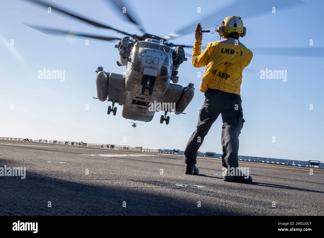 Boatswain's Mate der US Navy signalisiert den Piloten eines CH-53E Super Hengstes. Stockfoto