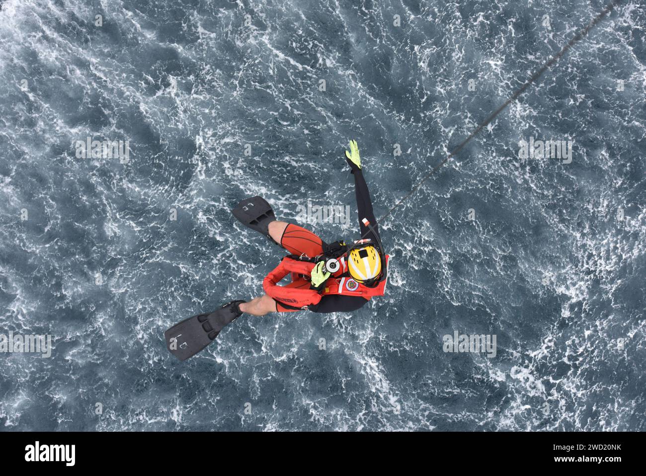 Ein Survival-Techniker wird von einem MH-60 Jayhawk Hubschrauber ins Wasser gesenkt. Stockfoto