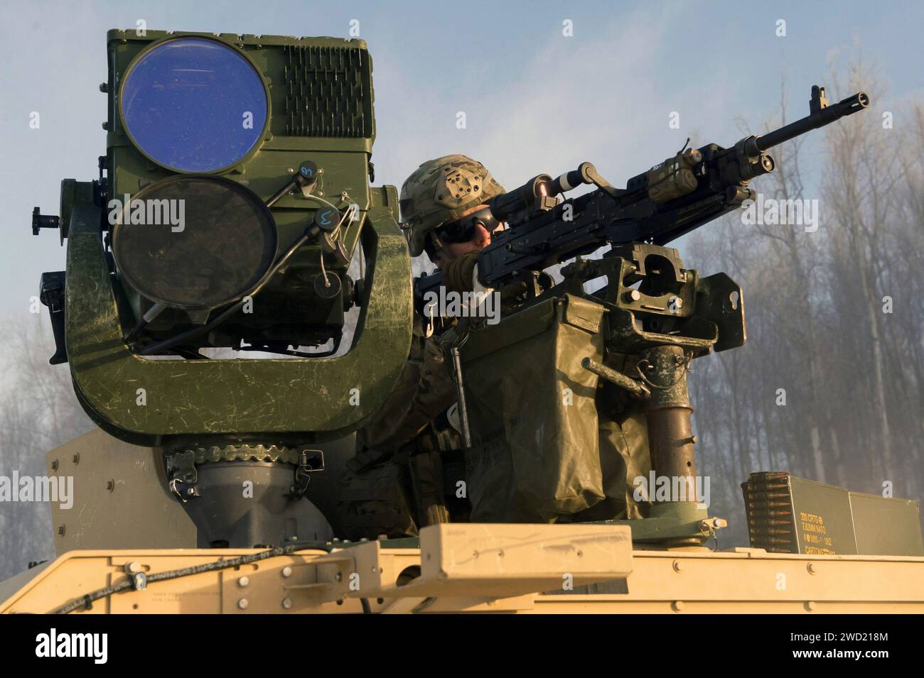 U.S. Army Specialist untersucht die Sichtbarkeit der Reichweite mit seiner Maschinenpistole. Stockfoto