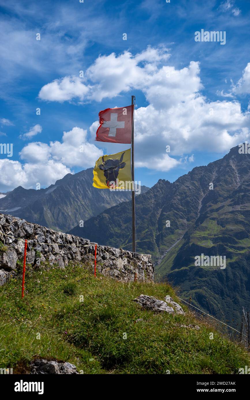 Schweizer Flagge eine Flagge des Kantons URI winkt im Wind auf einer Berghütte in der Schweiz Stockfoto
