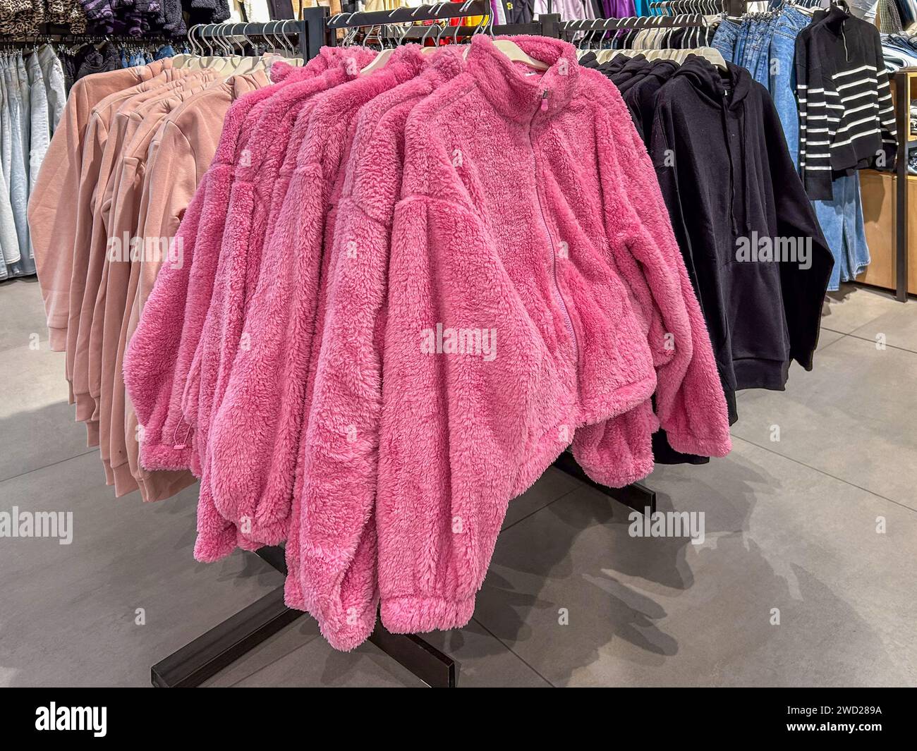 Pinkfarbene Fleecejacken für Damen auf der Wäscheleine zum Verkauf im Bekleidungsgeschäft Stockfoto
