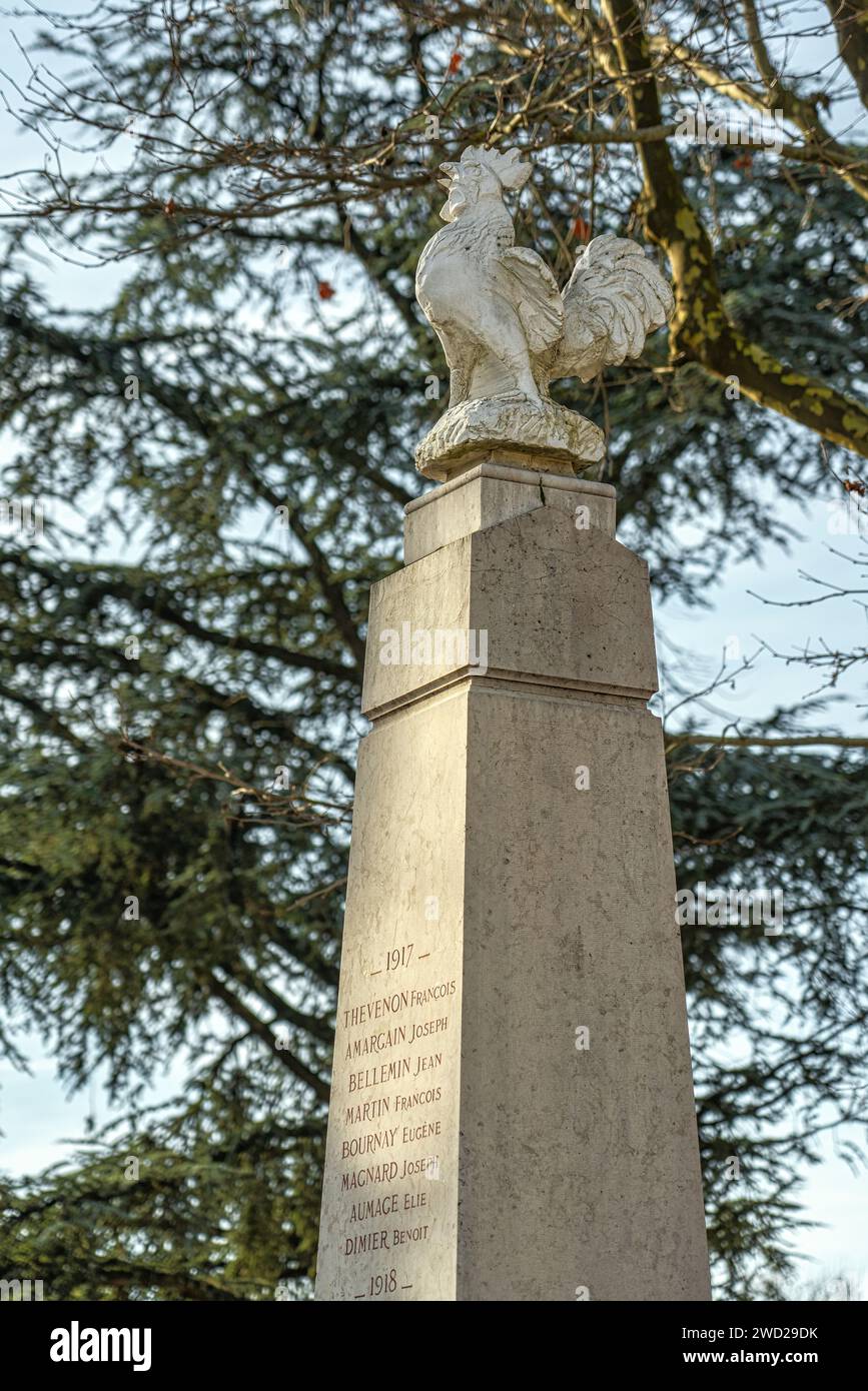 Das Kriegsdenkmal mit einem goldenen Hahn aus Metall oben, jetzt aus Harz, auf dem Stadtplatz. Villefontaine, Departement Isère, Frankreich Stockfoto