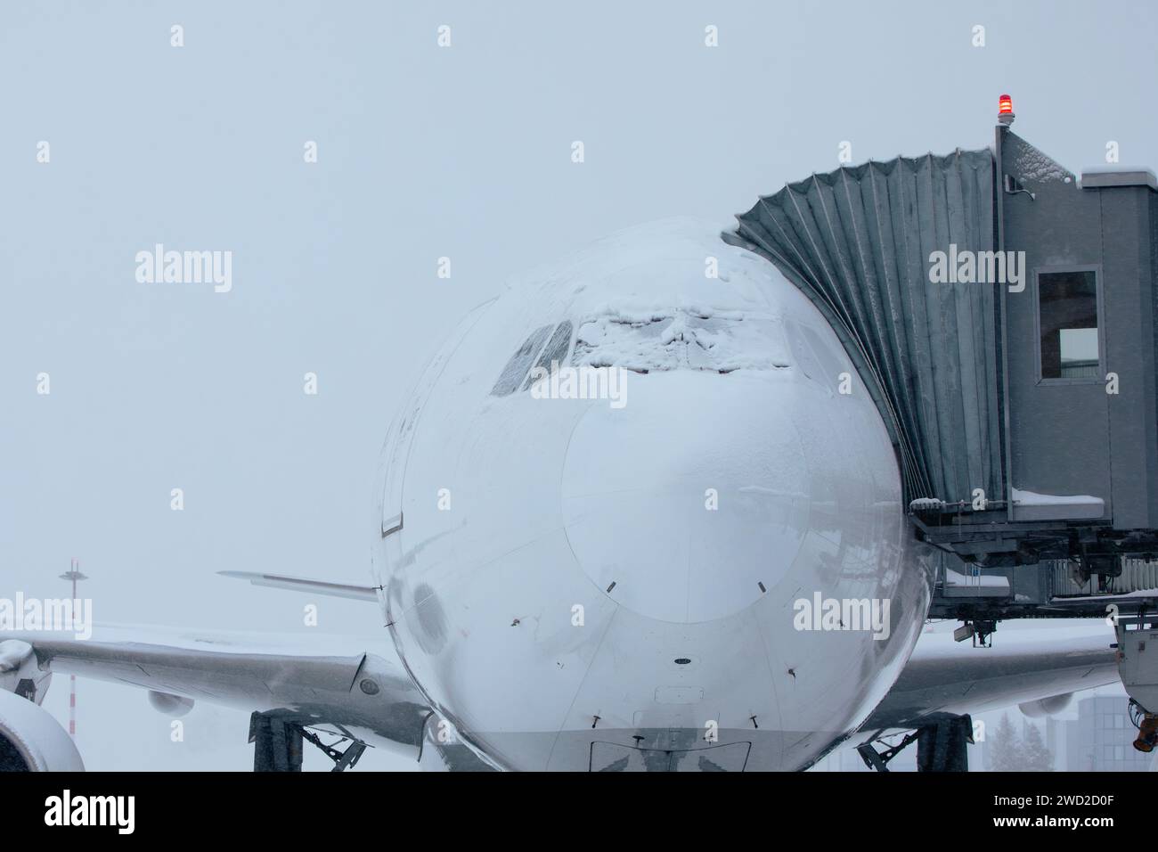 Der Flughafen ist bei starkem Schneefall geschlossen. Schneebedecktes Flugzeug an frostigen Wintertagen. Wetterextremen im Transport mit Kopierraum. Stockfoto