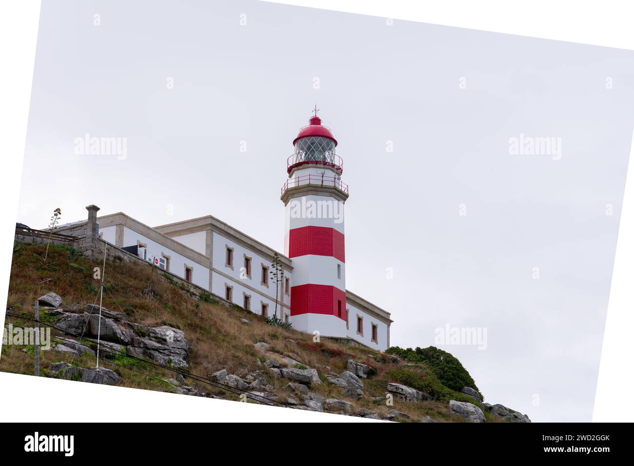 Der Leuchtturm Cabo Silleiro mit seinen roten Streifen auf dem felsigen Berg führt die Seeleute Stockfoto