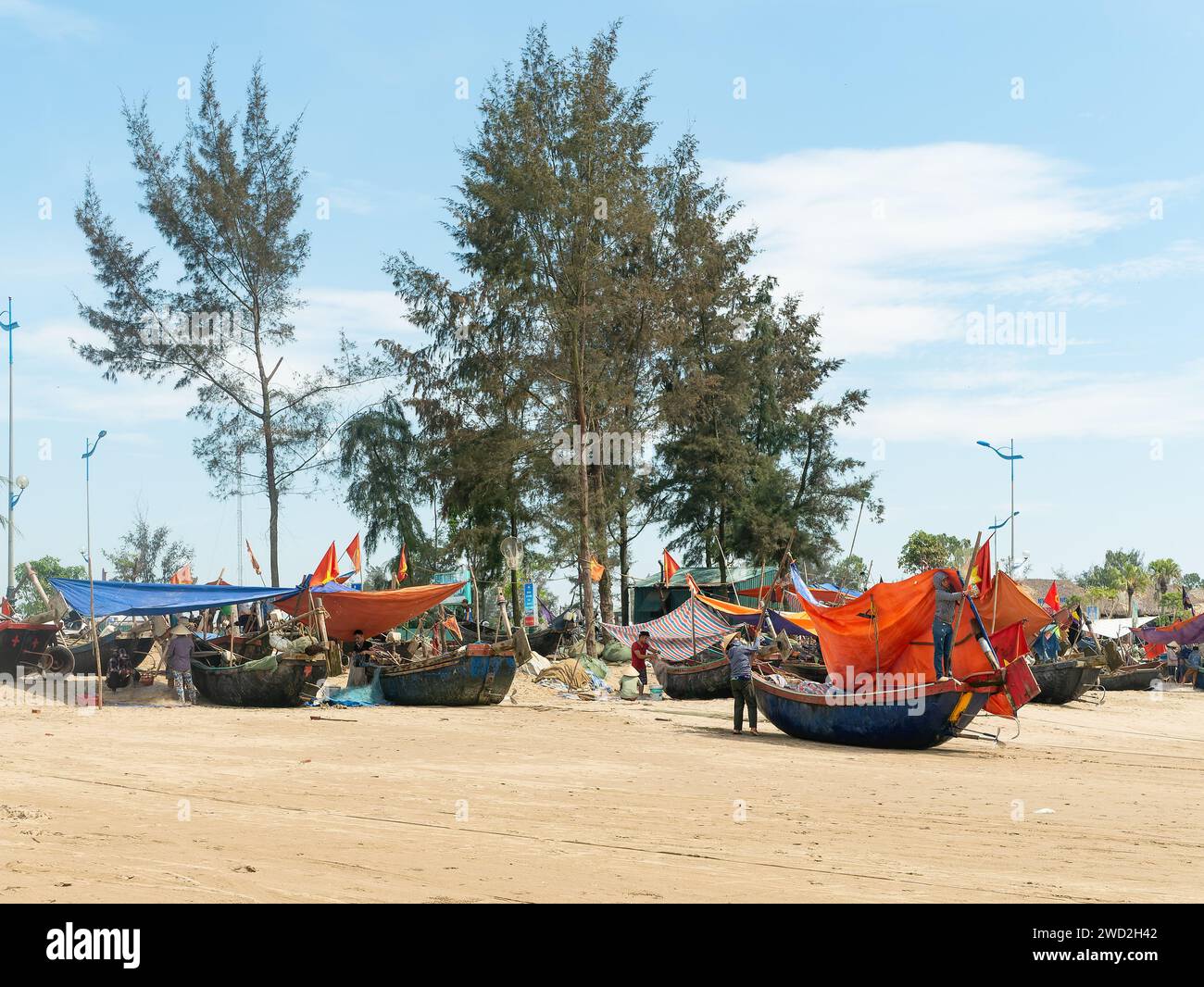 Fischer am Sam Son Beach, Thanh Hoa, Vietnam, mit ihren Booten am Strand am Ende des Arbeitstages. Die Boote sind aus Holz gebaut, aber überdacht Stockfoto