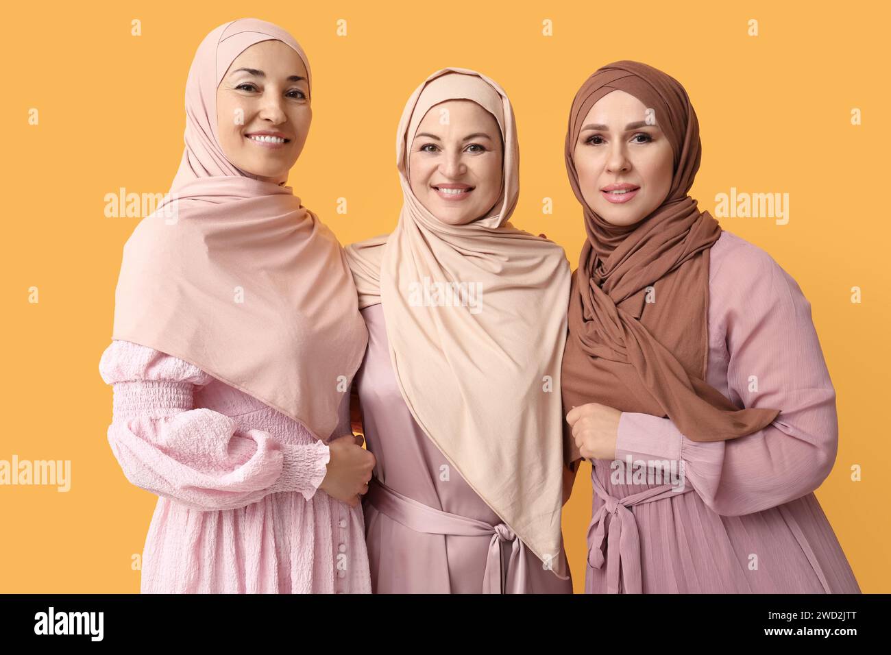 Schöne reife muslimische Frauen auf gelbem Hintergrund. Internationaler Frauentag Stockfoto