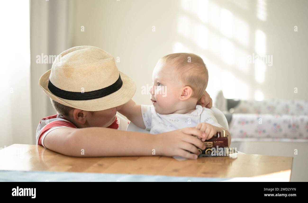 Lächelnde Brüder spielen zusammen. Familie mit Kindern zu Hause. Liebe, Vertrauen und Zärtlichkeit Stockfoto