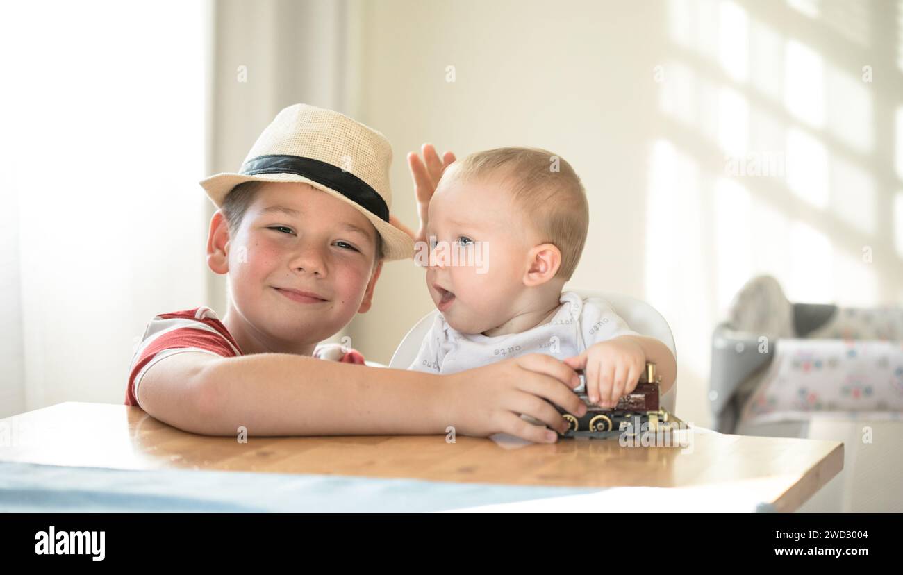 Lächelnde Brüder spielen zusammen. Familie mit Kindern zu Hause. Liebe, Vertrauen und Zärtlichkeit Stockfoto