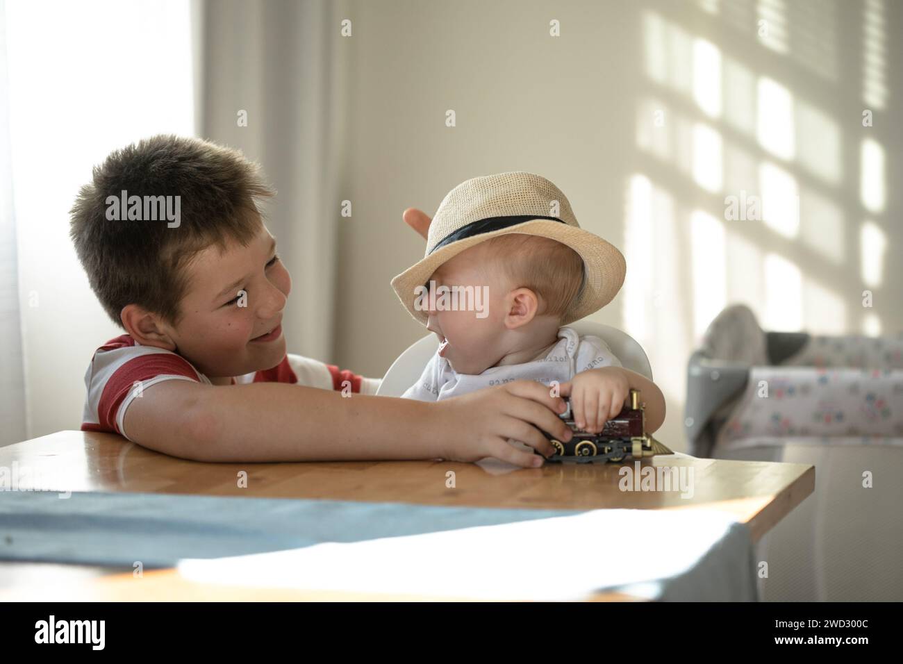 Lächelnde Brüder spielen zusammen. Familie mit Kindern zu Hause. Liebe, Vertrauen und Zärtlichkeit Stockfoto