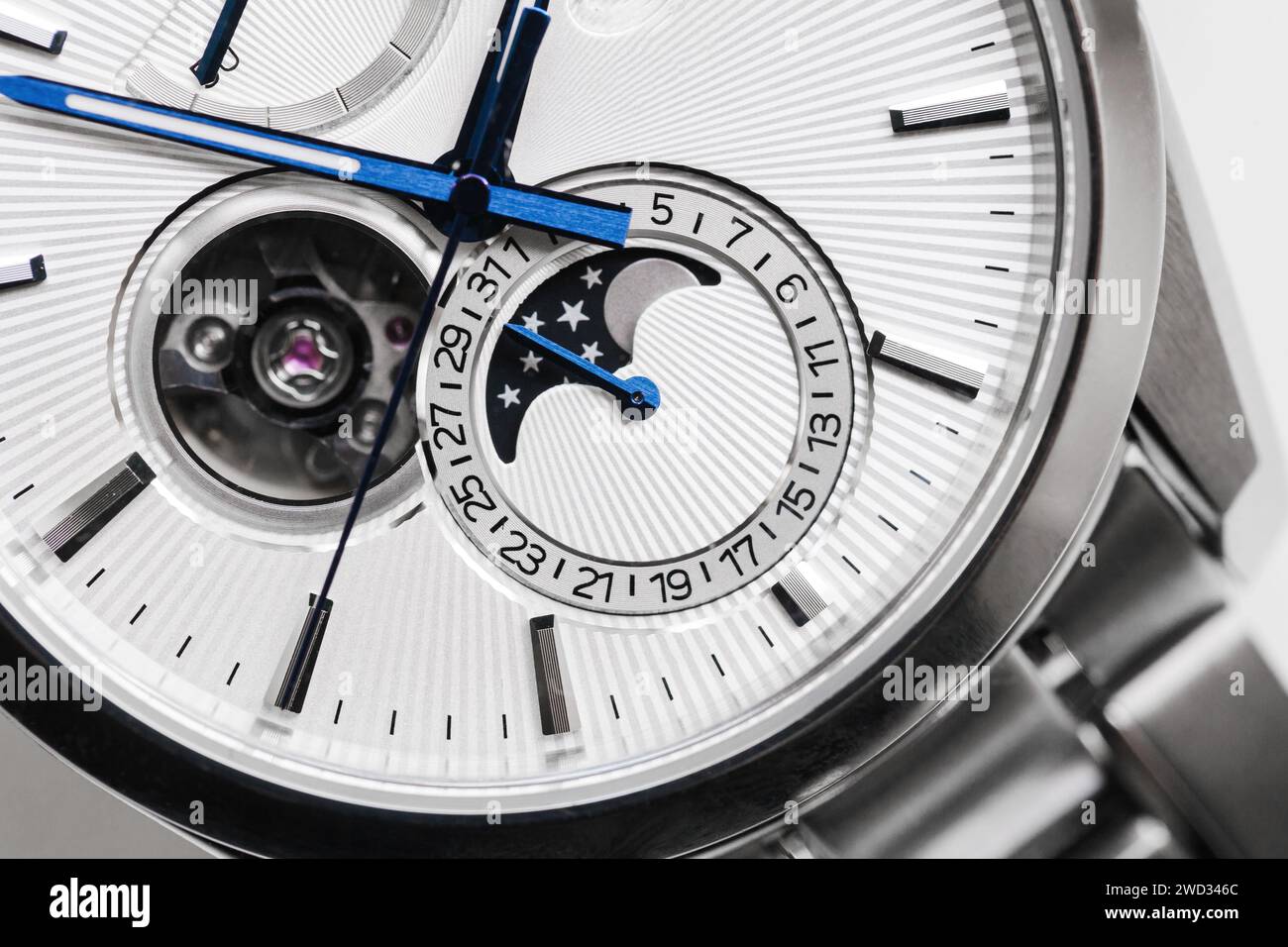 Makrofoto einer mechanischen Mondphasenarmbanduhr. Runder retrograder Kalender und Mondphasenanzeige befinden sich auf der weißen Stirnseite Stockfoto