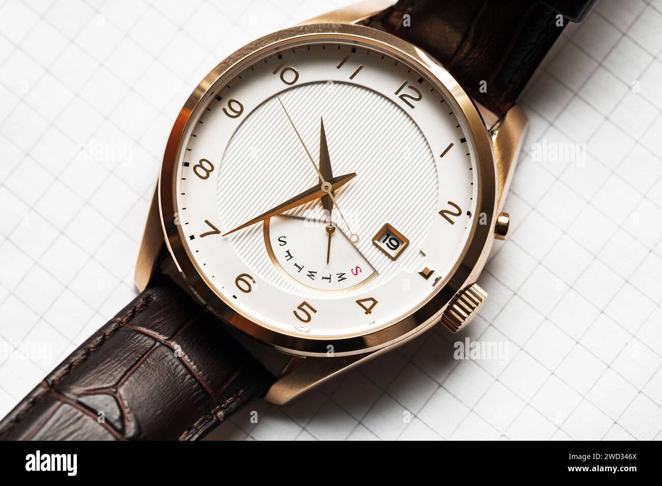 Klassische Armbanduhr mit weißer Uhr und goldenen Zeigern, Studio-Nahaufnahme, Draufsicht Stockfoto