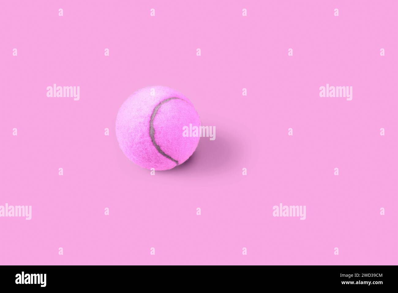 Pinker Tennisball mit Schatten auf rosa Hintergrund. Einfache Stop-Motion-Sport-Animation Stockfoto