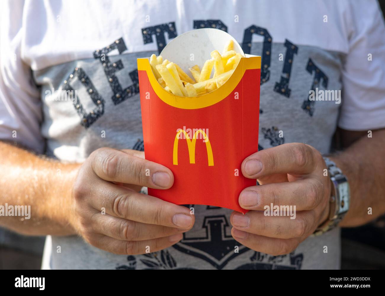 Der Mann hält eine Papiertüte mit Pommes Frites von McDonalds in der Hand. Das Konzept von Fast Food und Take-away-Food. Kiew, Ukraine, 08. Juli 2023 Copyright: XDmytroxNikolaienkox Stockfoto