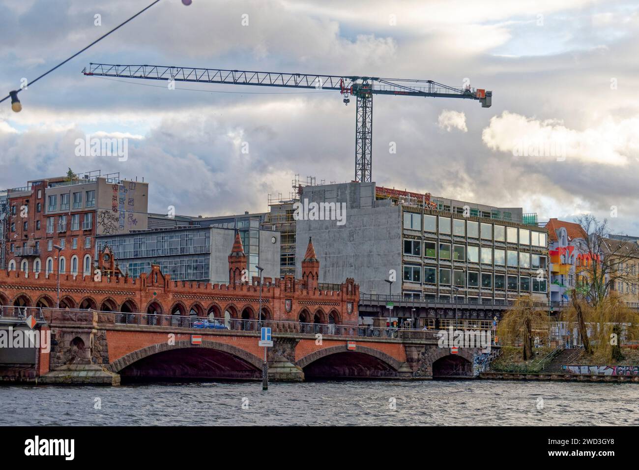 Neubau an der Oberbaumbrücke, Spree, Berlin-Kreuzberg. Das Graffiti vom Künstler Blu wurde übermalt. Stockfoto