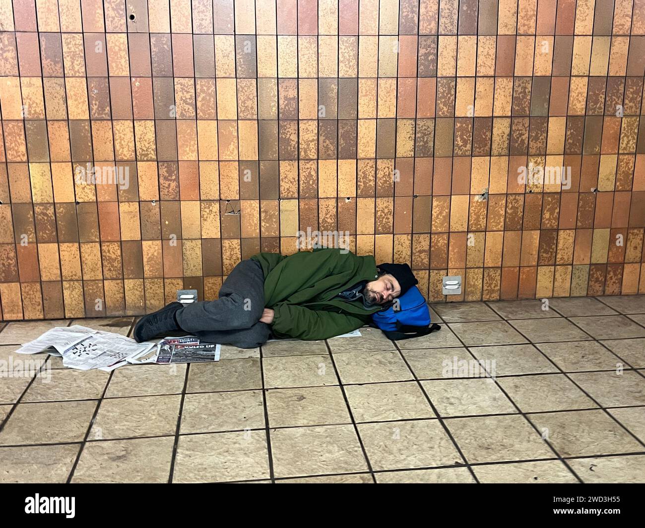 Obdachloser sucht Unterschlupf und schläft im Winter in einer New York City U-Bahn-Station. Stockfoto