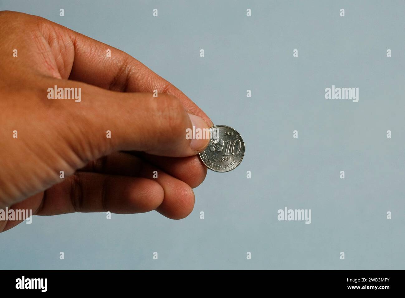 Nahaufnahme Hand hält 10 Cent Münze Malaysia. Wohltätigkeitskonzept. Stockfoto