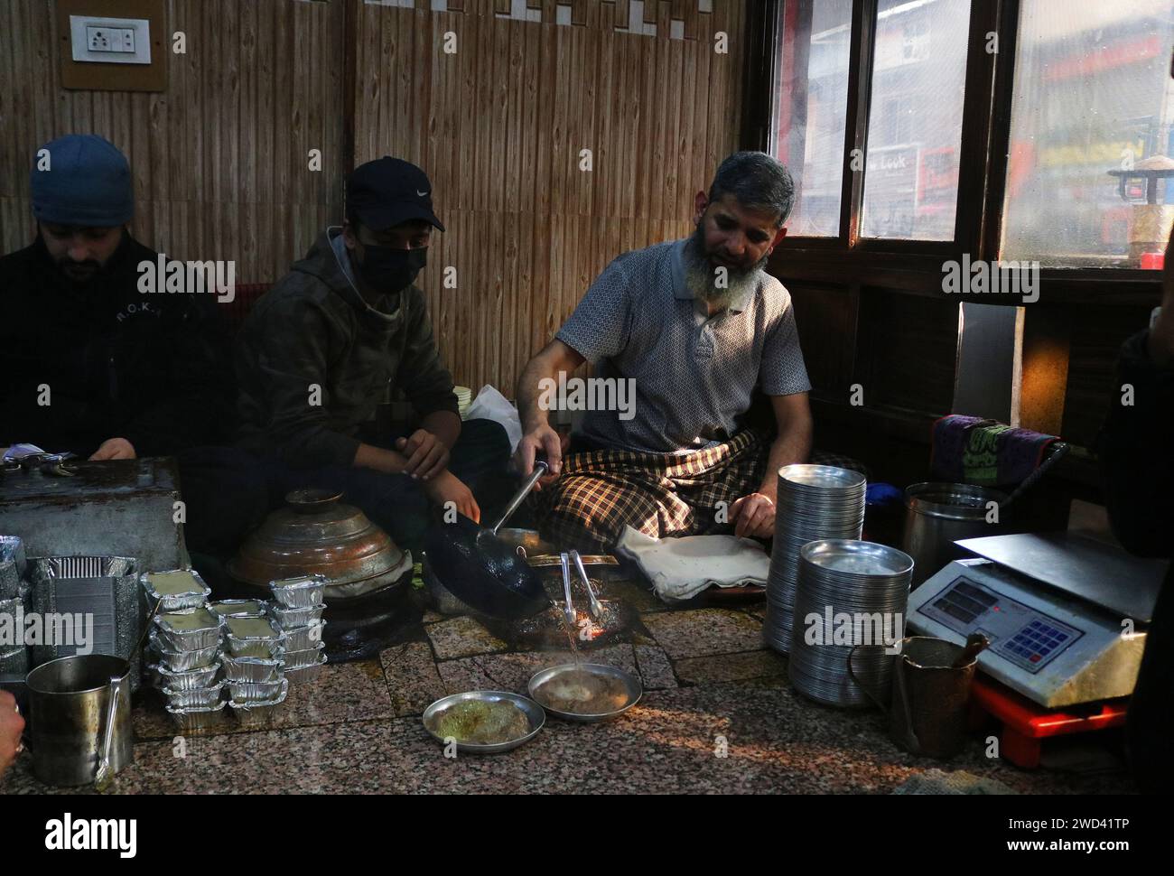 18. Januar 2024, Srinagar Kashmir, Indien: Ein Koch serviert Harissa an einem kalten Morgen in Srinagar. Harissa ist ein einzigartiges uraltes Hammelrezept, das während der Winter in Kaschmir zubereitet wird. Es ist meistens in den Morgenstunden aus Hammelfleisch, besonders von Schafen, erhältlich. Das Hammelfleisch wird zuerst bei milder Temperatur gekocht und alle Knochen werden extrahiert, um es entbeint zu machen. Das Hammelfleisch wird dann mit Reismehl, Wasser und verschiedenen Gewürzen gemischt und ständig umgerührt, bis es quaschig wird. Die Leute mögen dieses Gericht meistens mit gebackenem Brot. Am 18. Januar 2024 In Srinagar Kaschmir, Indien. (Foto Von Firdous Naz Stockfoto