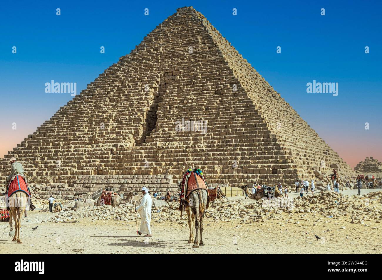 Gizeh Necropolis, Ägypten - 26. April 2022: Beduinen in traditionellen Kleidern und Touristen, vor dem Pyramidenkomplex von Gizeh Necropolis. Stockfoto
