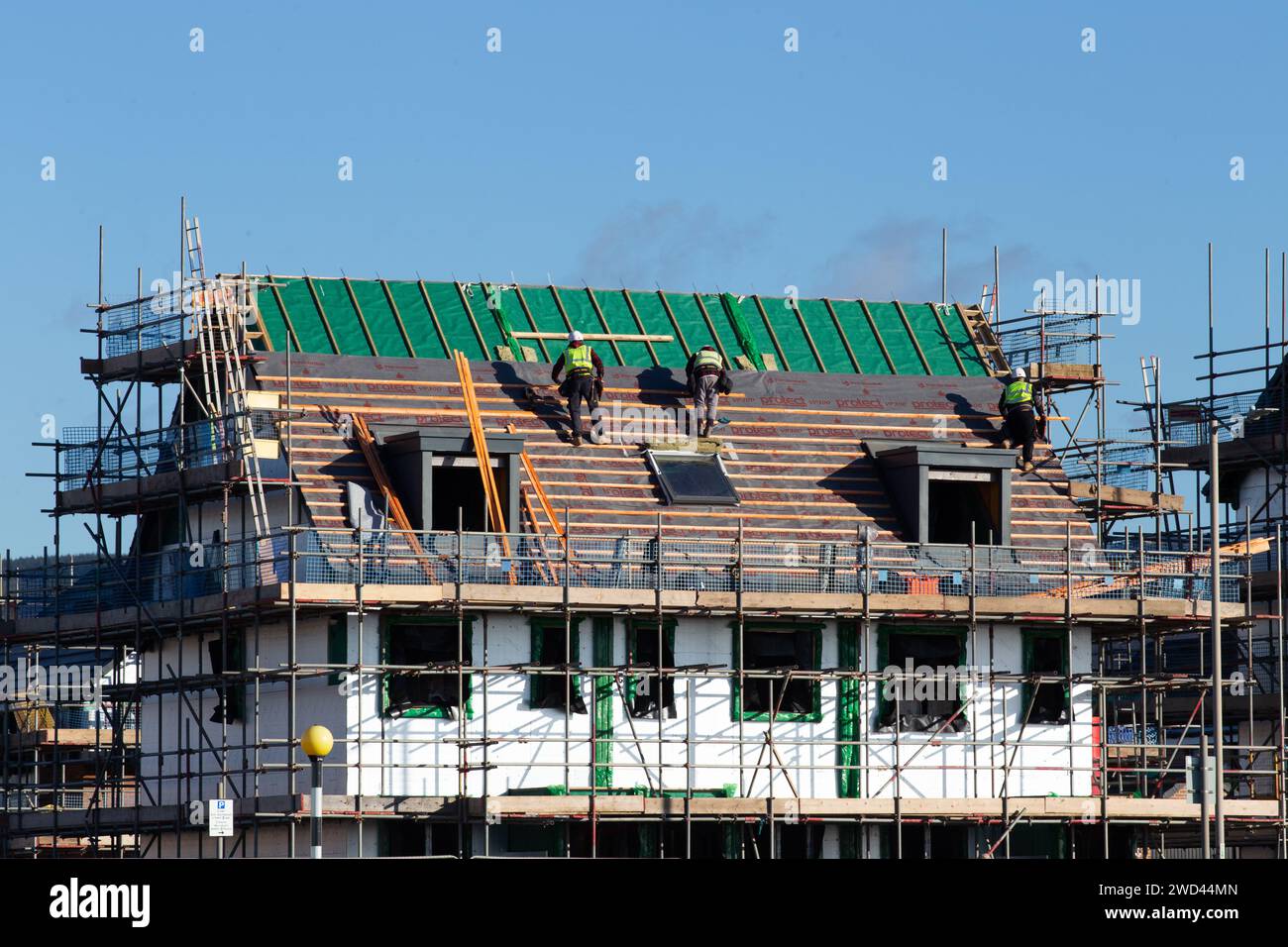 Arbeiter, die das Dach eines neu erbauten Persimmon House in Port Talbot, South Wales, Vereinigtes Königreich, montieren Stockfoto