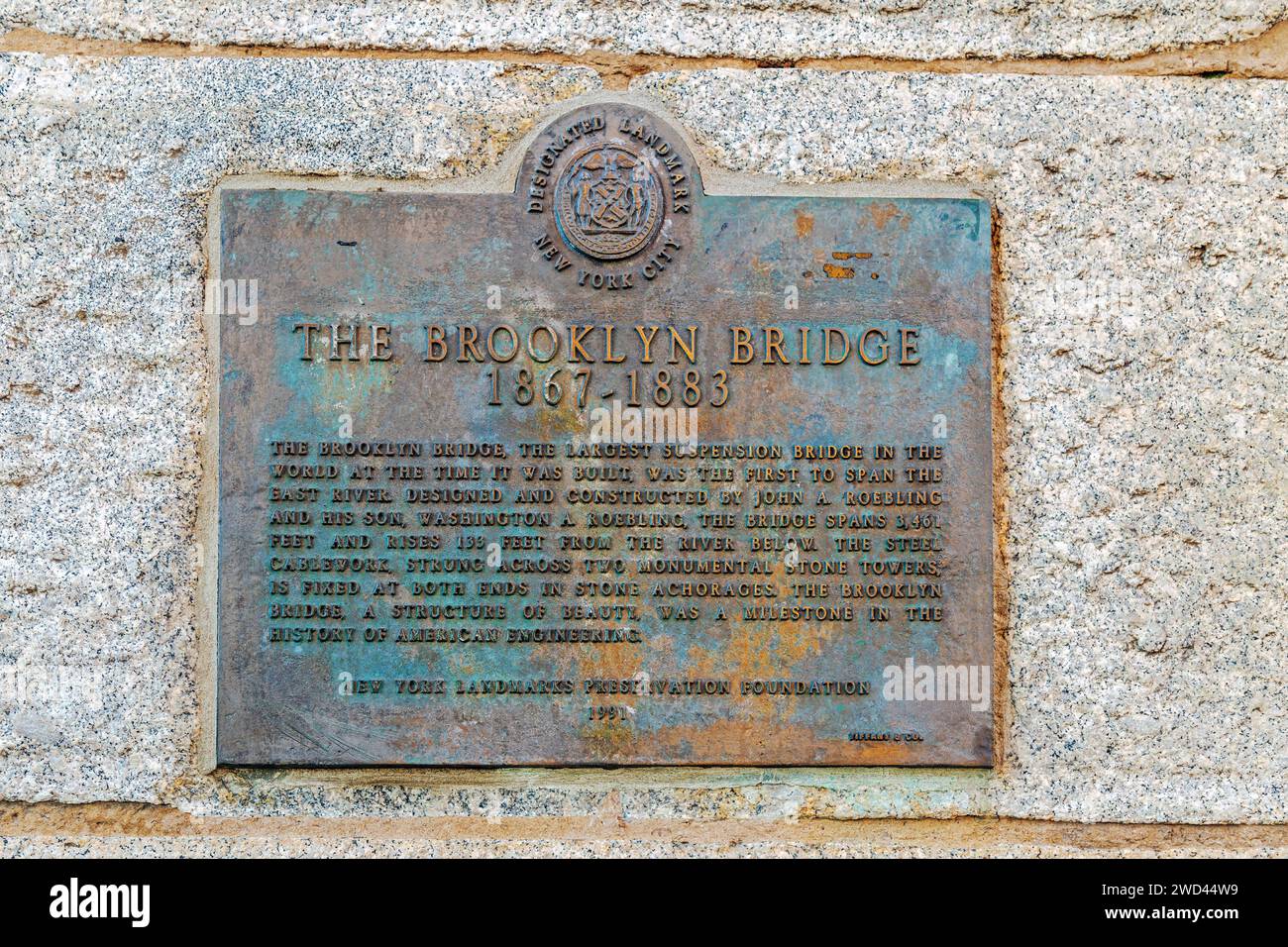 NEW YORK, MANHATTAN-USA 9. MÄRZ 2020: Beschreibende Gedenktafel mit der Brooklyn Bridge, einer hybriden Seilbrücke, die den East River überspannt. Stockfoto