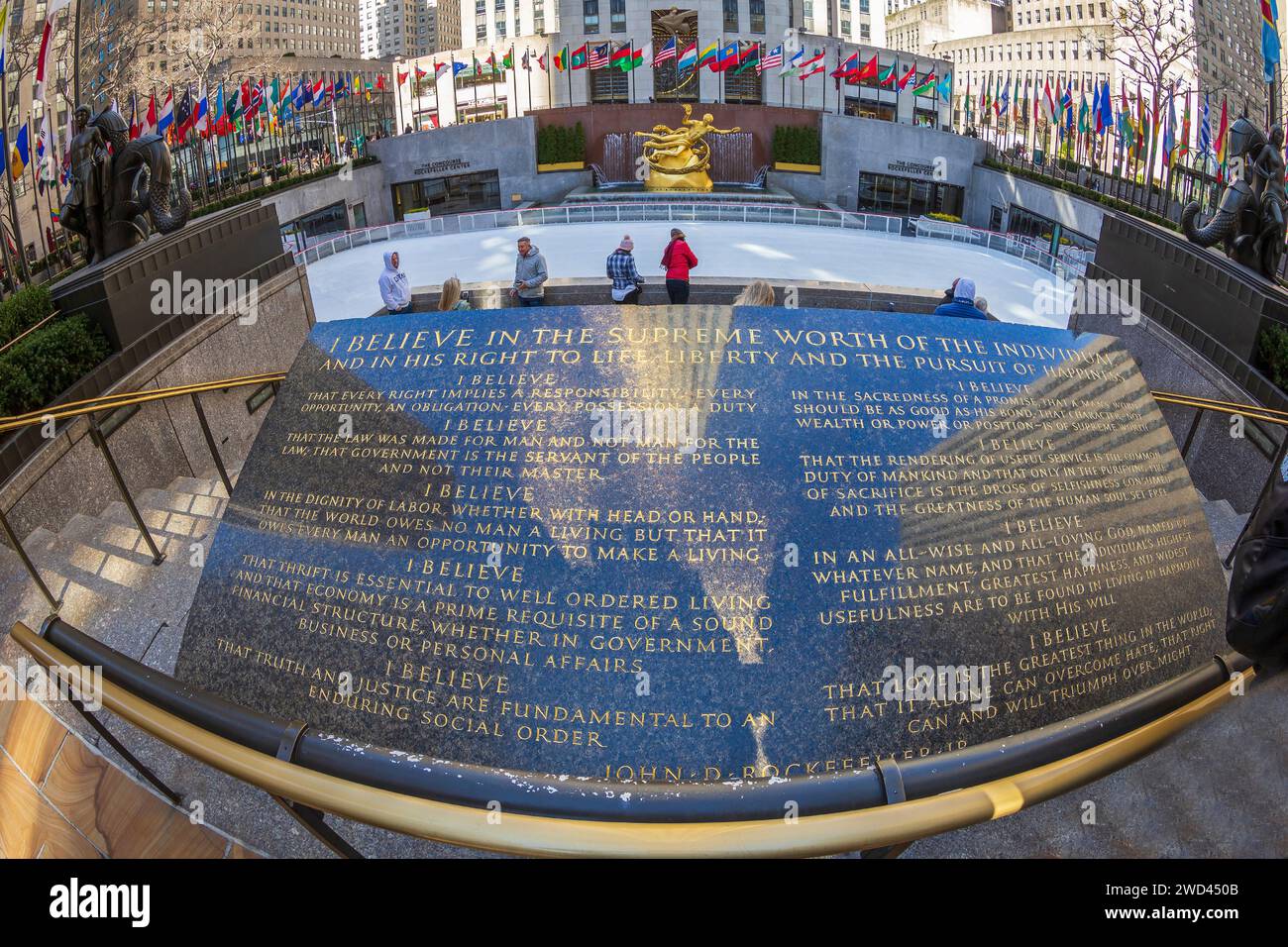NEW YORK, USA - 7. MÄRZ 2020: Beschreibende Gedenktafel mit den Worten von John D. Rockefeller Jr., Eislaufbahn und Prometheus-Statue auf dem Rockefeller Plaza. Stockfoto