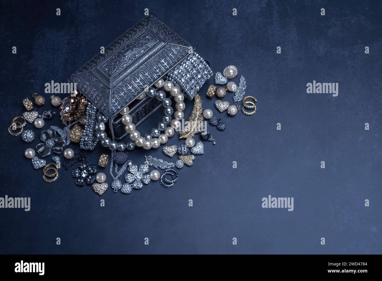 Verschiedene Schmuckstücke Perlen Gold und Silber in einer silbernen Box auf schwarzem Hintergrund. Armbänder, Ohrringe, Ketten, Mode, Accessoires, Schmuckkonzept. Stockfoto