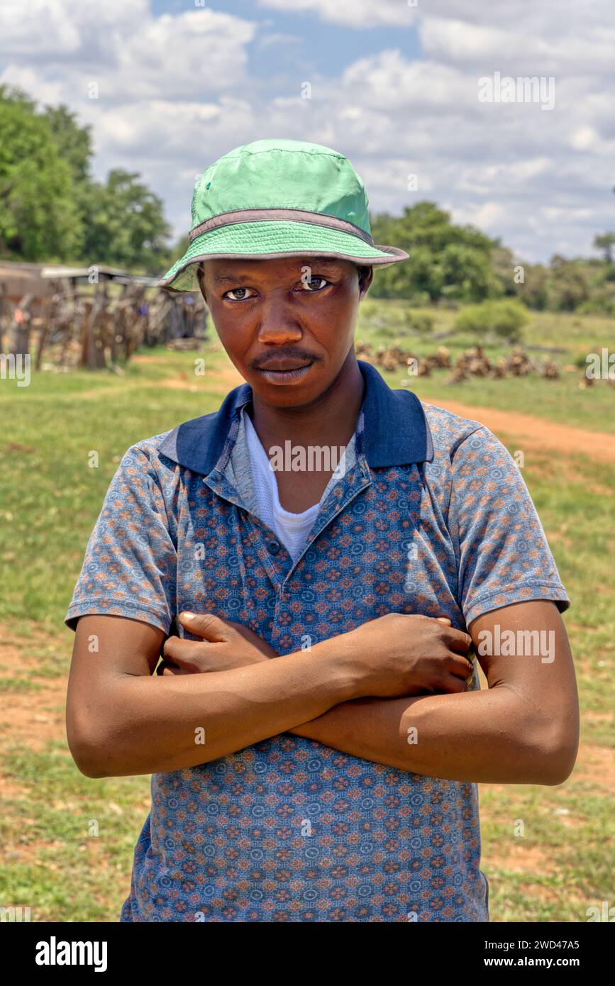 Junger afrikanischer Mann mit grünem Hut im Dorf an einem Sommertag Stockfoto