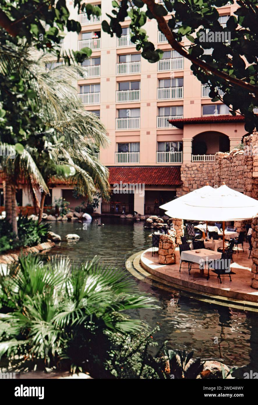 Open-Air-Essbereich mit Blick auf einen Lagunenpool im Aruba Hyatt Resort CA. Ende der 1990er Jahre Bitte schreiben Sie dem Fotografen Joan Iaconetti zu Stockfoto