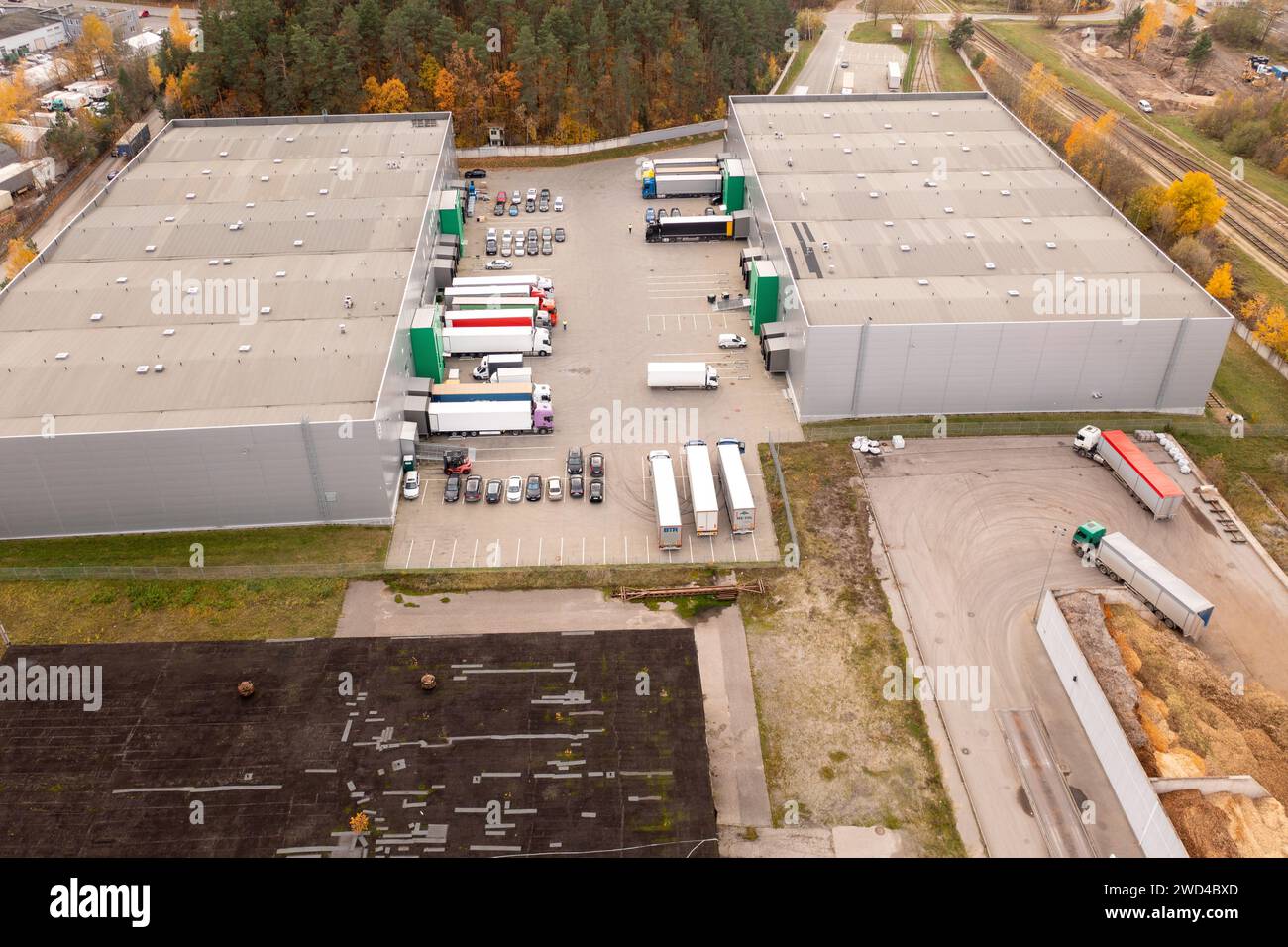 Drohnenfotografie eines kleinen Logistiklagers mit geparkten LKW an sonnigen Herbsttagen Stockfoto