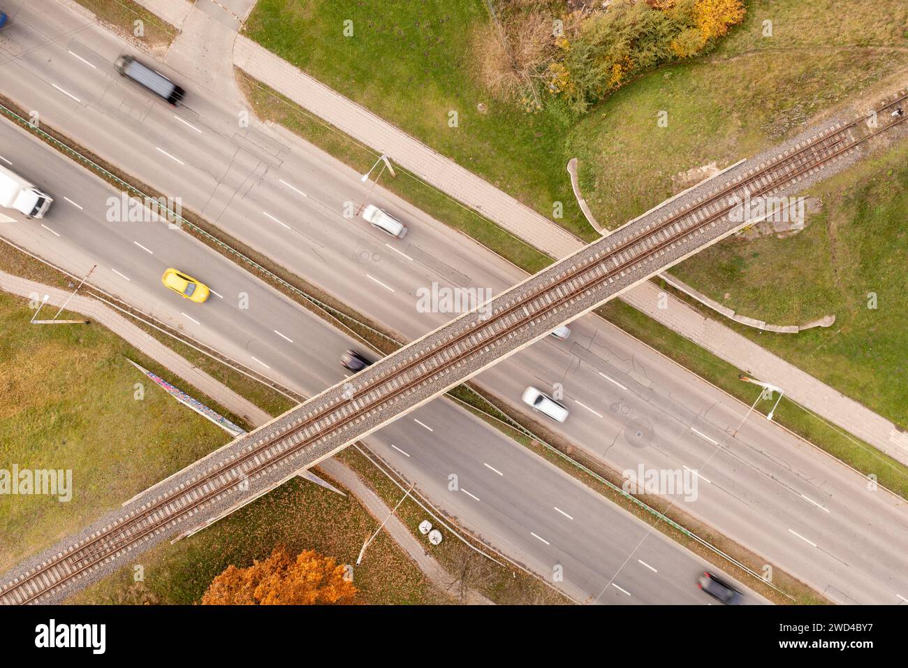 Drohnenfotografie der Eisenbahnbrücke, die über die Autobahn führt, während der sonnigen Herbsttage Stockfoto