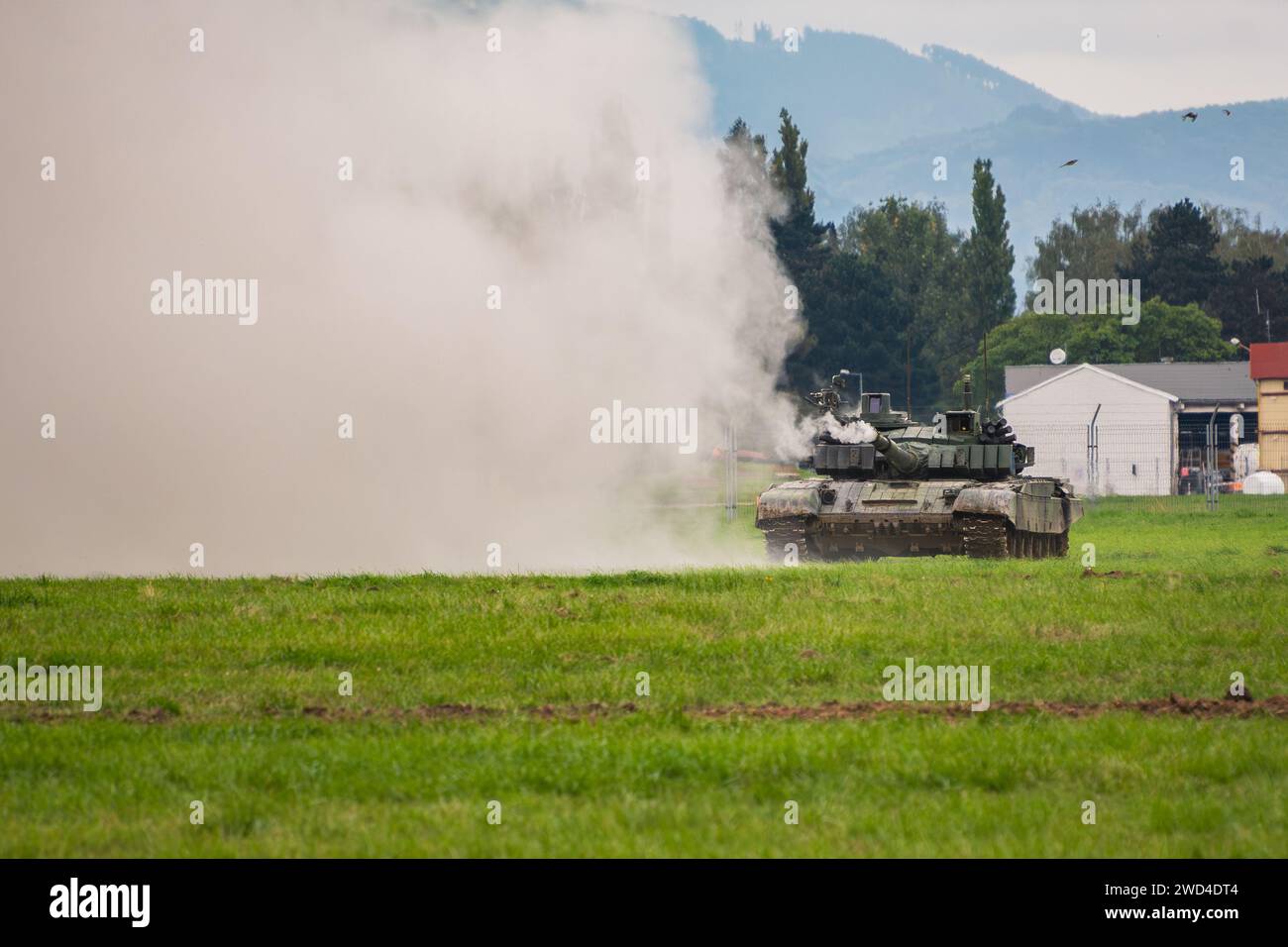 T-72 Kampfpanzer (M4 – CZ-Variante), der seine Hauptkanone auf einem grünen Feld während einer Kriegsspielprobe abfeuert. Stockfoto T-72 Kampfpanzer (M4 – CZ-Variante), der seine Hauptkanone auf einem grünen Feld während einer Kriegsspielprobe abfeuert. Stockfoto