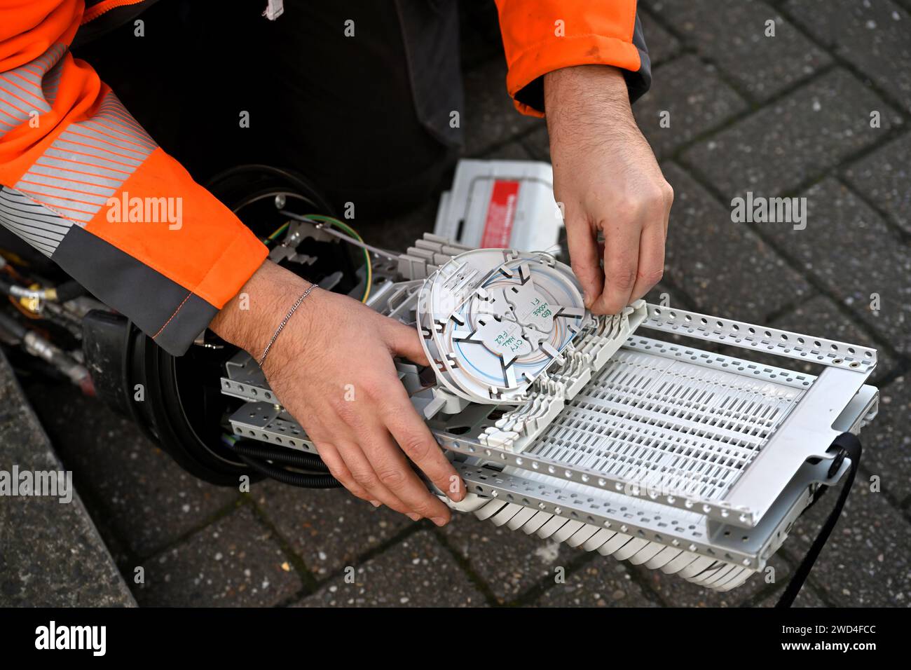 Ingenieur, der an der Instillation von Glasfaserkabeln in Anschlusskasten für unterirdische Entenarbeiten arbeitet, Großbritannien Stockfoto Ingenieur, der an der Instillation von Glasfaserkabeln in Anschlusskasten für unterirdische Entenarbeiten arbeitet, Großbritannien Stockfoto