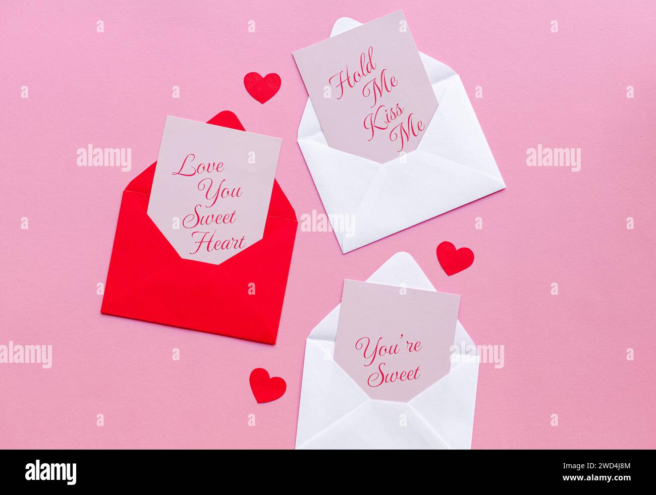 Valentinskarten auf Umschlag mit herzförmigen Papierherzen Stockfoto