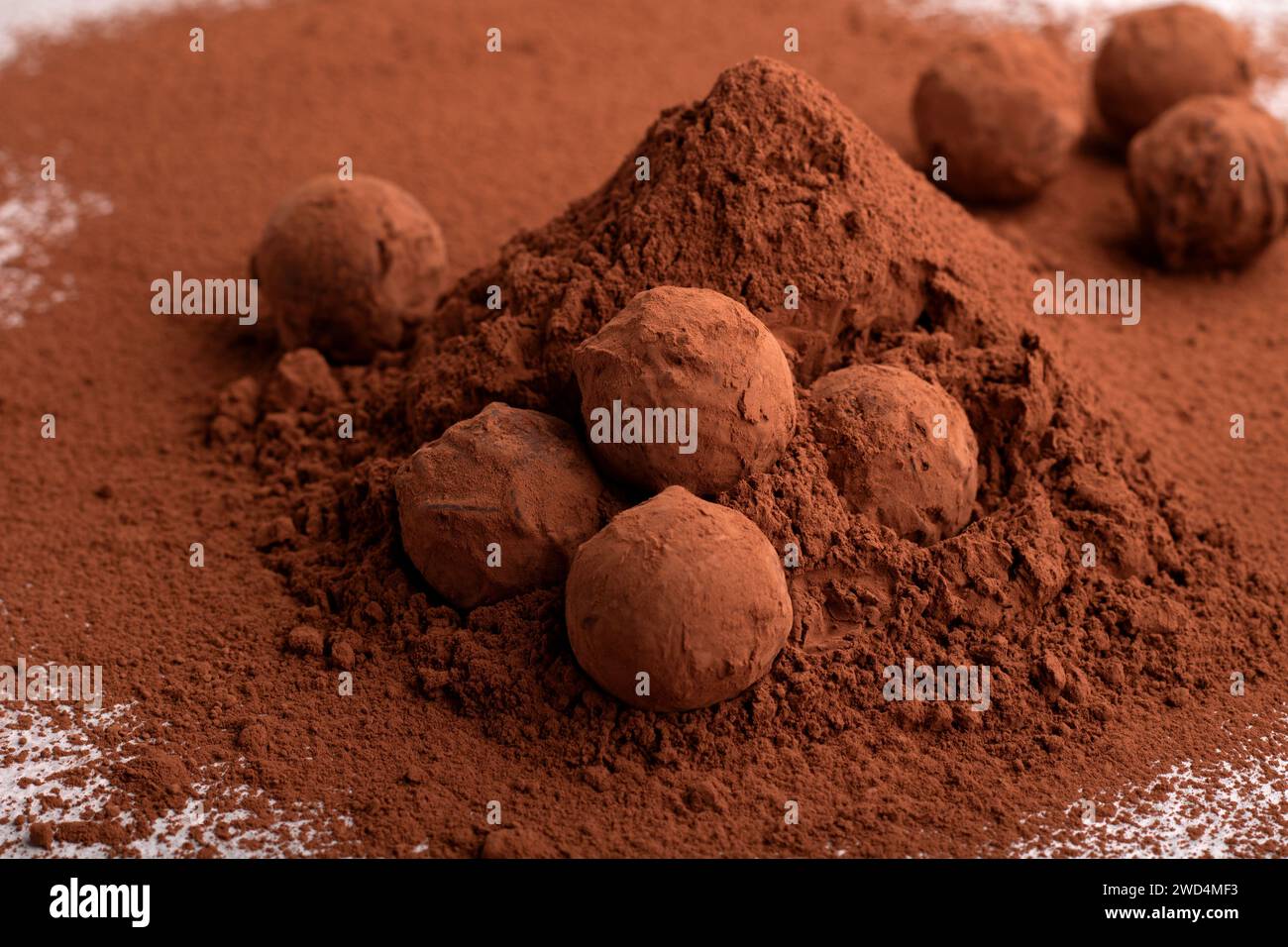Die horizontale Fotografie ist ein Haufen handgemachter dunkler Schokoladentrüffel mit Kakaopulver. Dieses Meisterwerk der Süßwaren vereint reiche Aromen Stockfoto