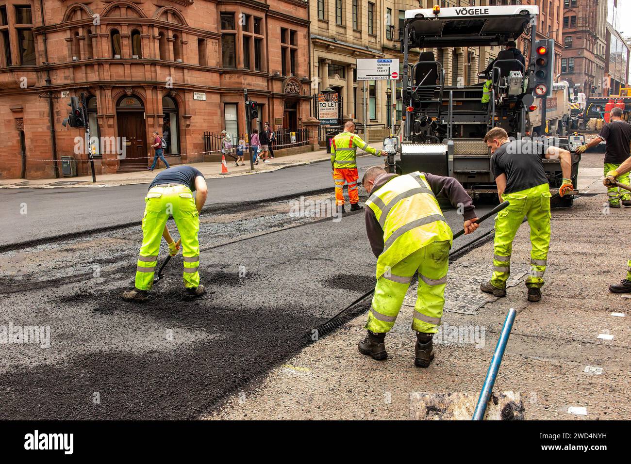 Arbeiten an der Reparatur von Schlaglöchern im Stadtzentrum von Glasgow zur Vorbereitung des UCI Cycling Events. Stockfoto