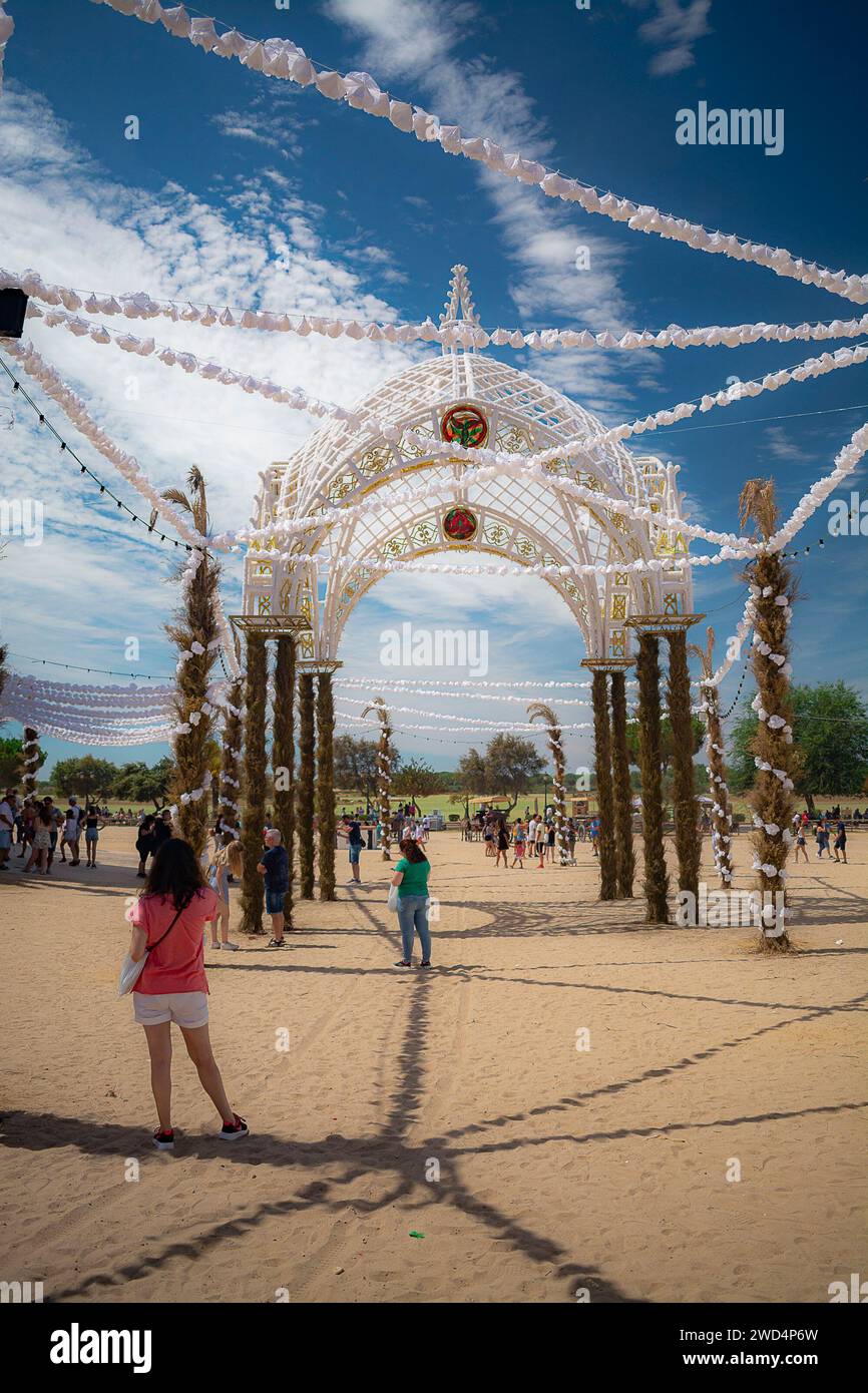 Menschen, die einen sonnigen Tag am Strand genießen, versammeln sich in der Nähe eines bezaubernden weißen Pavillons Stockfoto