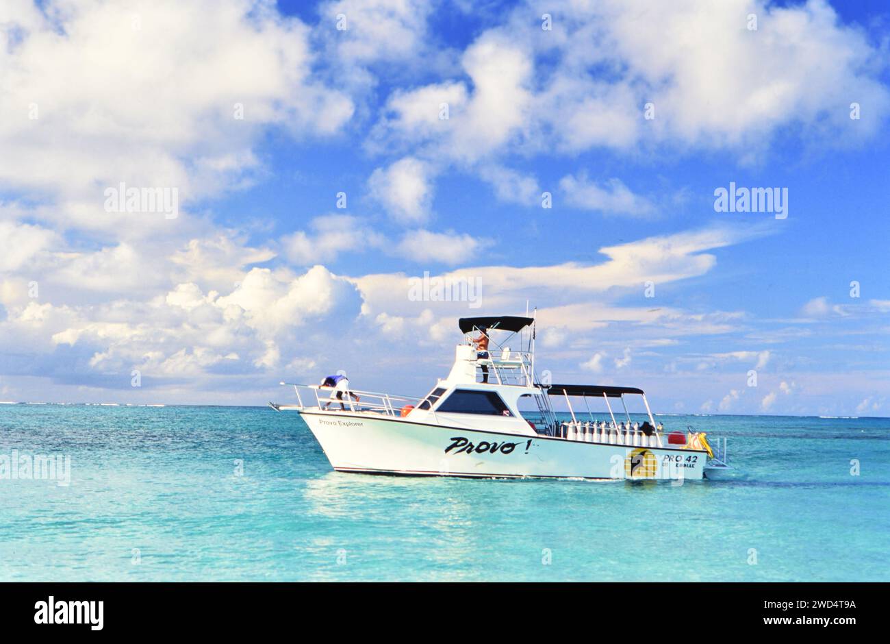 Provo Explorer Boot, unter teilweise bewölktem Himmel in ruhigem kristallblauem Wasser ca. 1990er Jahre Bitte schreiben Sie der Fotografin Joan Iaconetti zu. Stockfoto