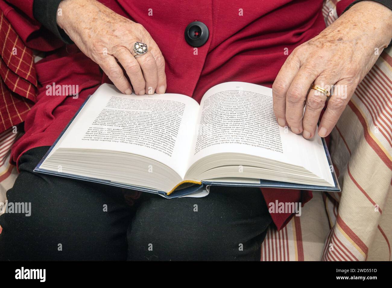 Buchleser. Eine ältere Frau liest ihr Buch, das auf ihrem Schoß liegt Stockfoto