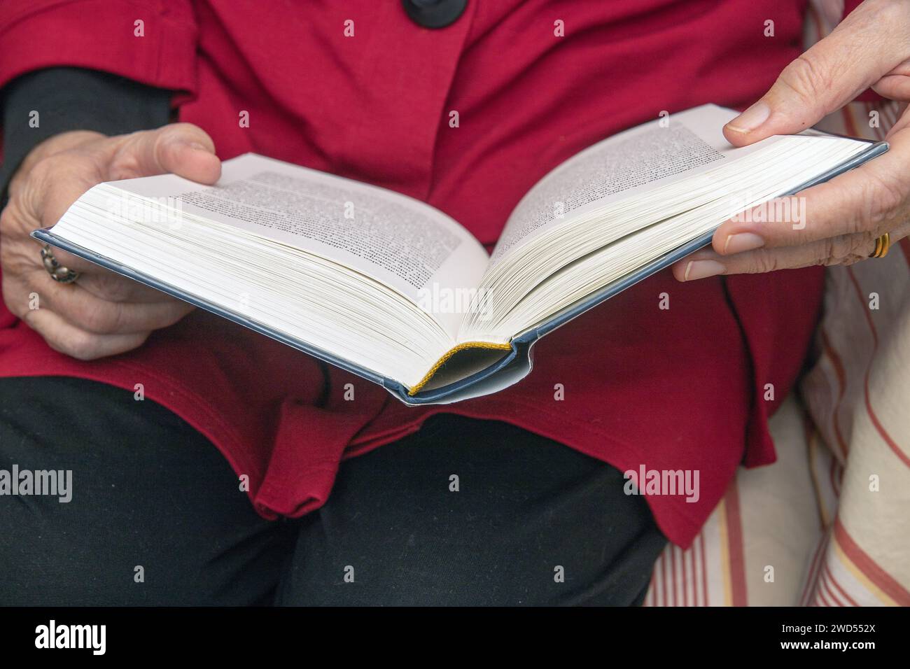 Buchleser. Eine ältere Frau liest ihr Buch, das auf ihrem Schoß liegt Stockfoto