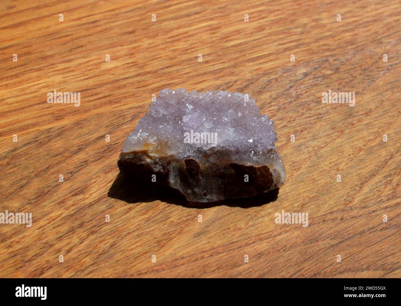 Schöne Fliedertrommel mit Amethyst-Kristallen auf hölzernem Hintergrund. Magische Halbedelsteine. Stockfoto