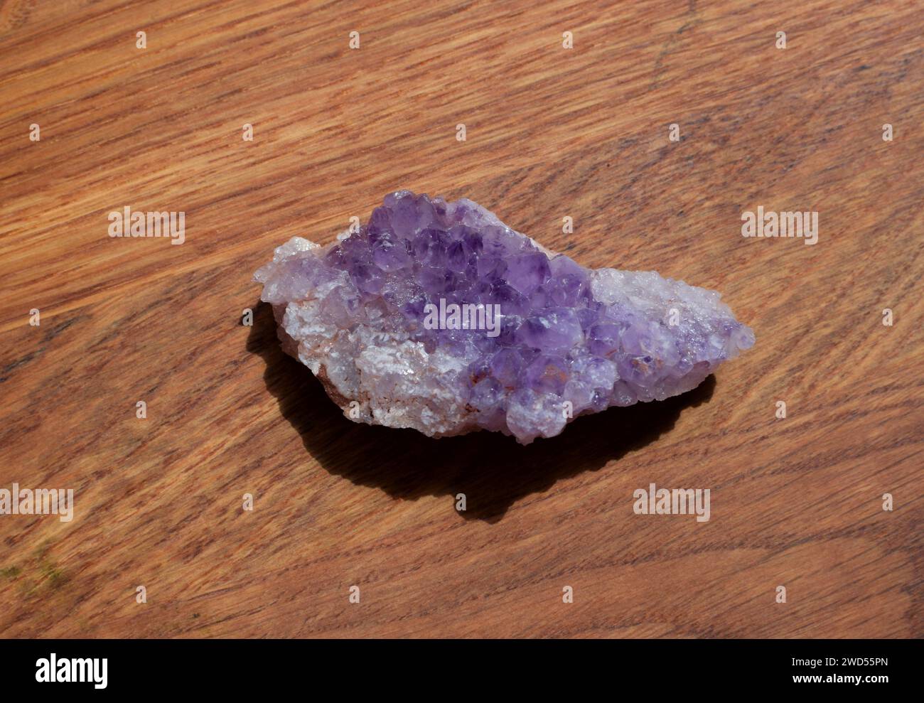 Schöne Fliedertrommel mit Amethyst-Kristallen auf hölzernem Hintergrund. Magische Halbedelsteine. Stockfoto