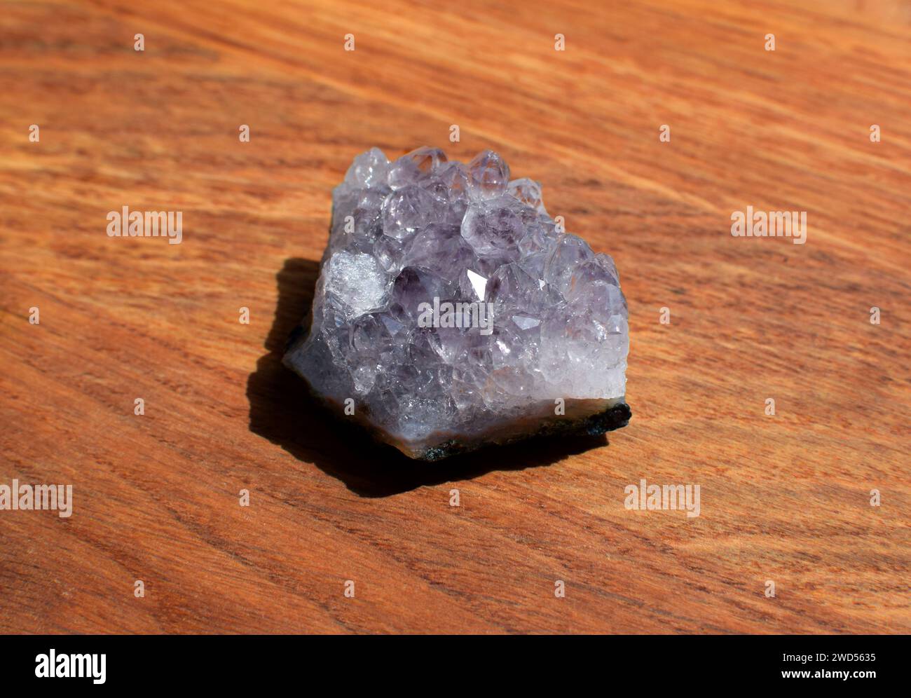 Schöne Fliedertrommel mit Amethyst-Kristallen auf hölzernem Hintergrund. Magische Halbedelsteine. Stockfoto