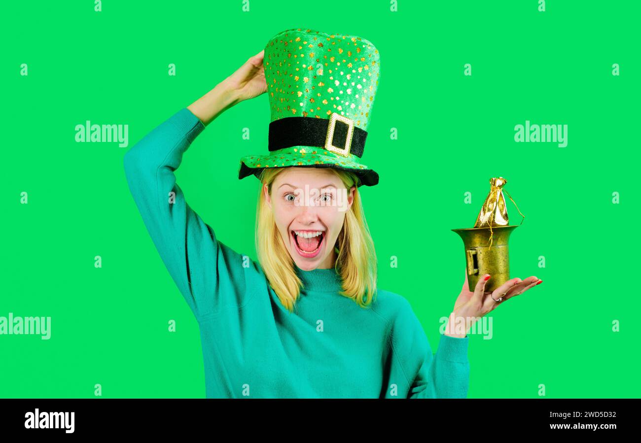 Glückliche Frau in grünem Hut mit einer kleinen Tasche Gold. Patricks-Feiertag. Pot Geld für Patricks Party. Blondes Mädchen in grünem Pullover Stockfoto